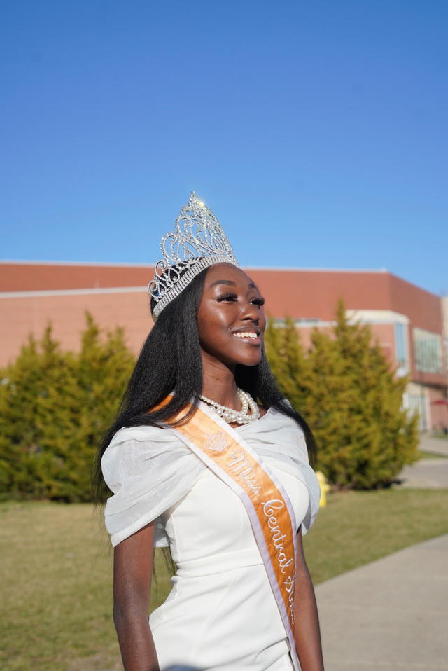 a young african american woman in a crown and sash looking toward the right in front of the central state university hallie q brown memorial library