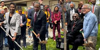 four people hold shovels before planting a tree at central state university in celebration of the ohio department of natural resources 75th anniversary