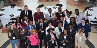 central state university scholars stand in a group while looking at a camera taking a photo from above