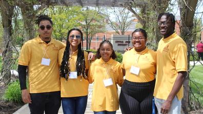 five students wearing nametags and central state university 1890 land-grant polos at the seed to bloom botanical and community garden in wilberforce ohio