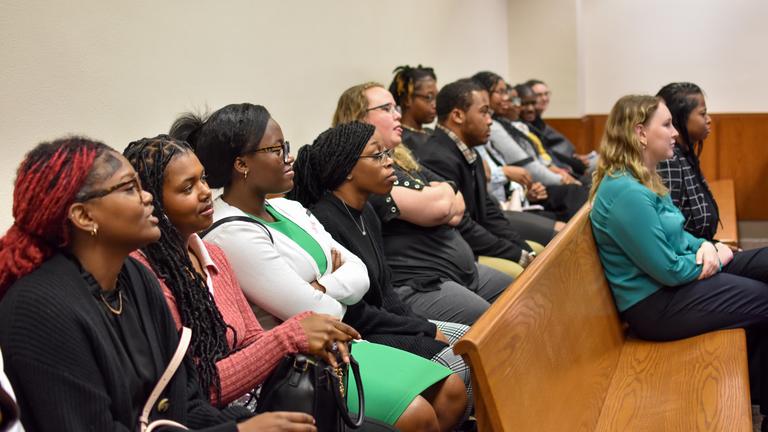 students sit in a courtroom