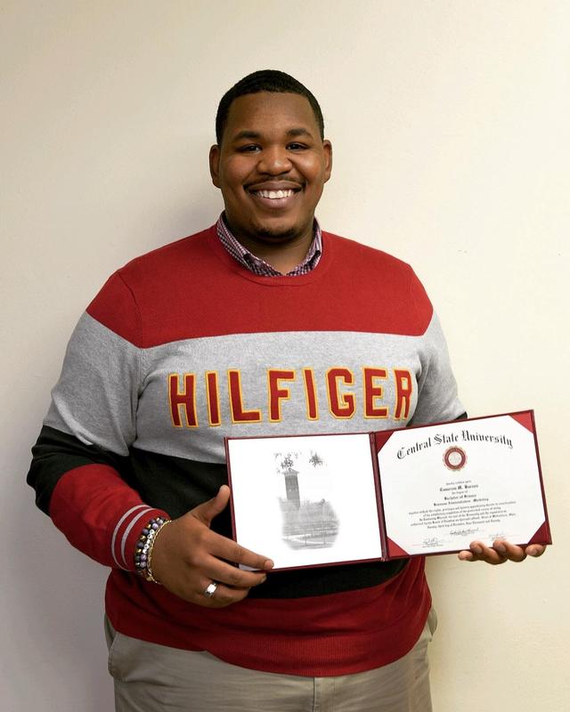 Cameron Barnes holding his diploma from Central State University