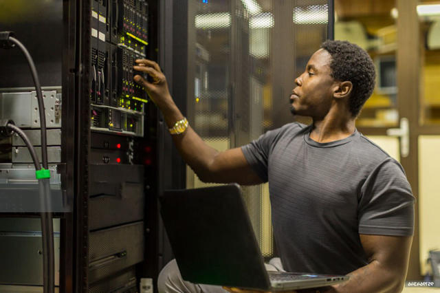 an African American man working on computer hardware technology equipment