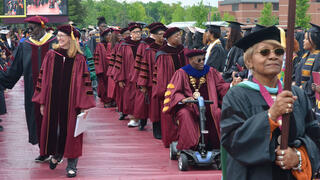 Faculty approaches the stage