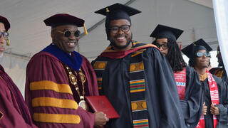 President Kuti stands on stage