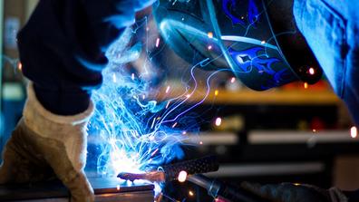 A person welds while wearing safety equipment
