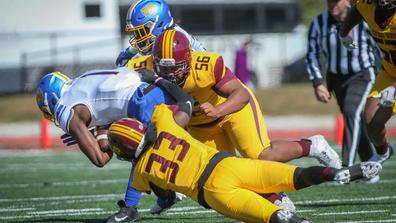 Two football players with Central State University Marauder Athletics tackle an opponent