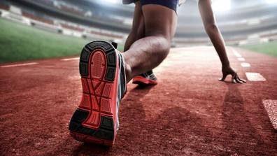 closeup of a runner preparing to race in a stadium