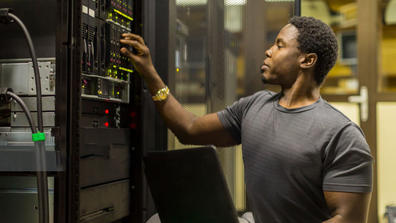 an African American man working on computer hardware technology equipment