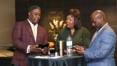 three people network at the inaugural rise to the challenge summit in 2022