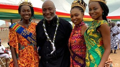 John Dunn and four young women in African cultural attire at a leadership trip with the NAACP in Accra Ghana