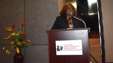 Patti Allen stands at a podium at the 2023 Black Farmers Conference held at the National Afro-American Museum and Cultural Center