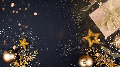 gold stars, gifts, and other holiday decor on a dark blue background