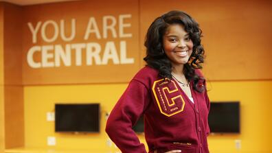 central state university student Asia Fuqua wearing maroon and gold beside a sign saying you are central