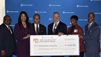 representatives from Central State University and Premier Health holding a large check for $10,000 in proceeds from the annual African American Wellness Walk in Dayton, Ohio