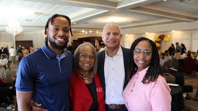 a young African American man stands with his mother and grandparents during the central state university cincinnati star alumni chapter's annual scholarship luncheon