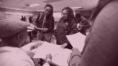 two african american students at ohio's only public H B C U with a professor holding assignments