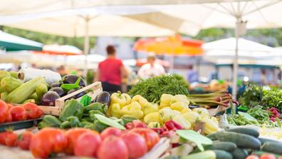 vegetables in the foreground of a farmers market