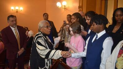 paula hicks-hudson passes out souvenirs to 4-H youth urban farmers