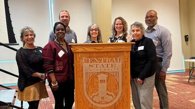 seven panelists stand around a podium at the soar summit at central state university
