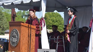 tristin fernandes and doctor amy hobbs harris on stage at the 2025 commencement ceremony at central state university