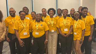 large group of people wearing gold shirts and lanyards
