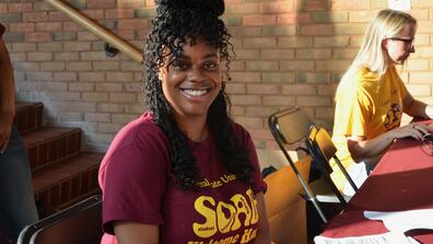 a young woman in a central state university t-shirt smiles at the camera