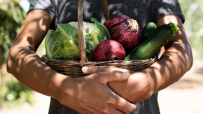 Young made holding a basket of vegetables
