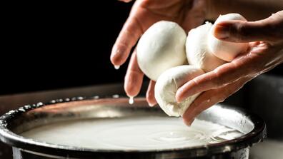 A woman making mozzarella cheese