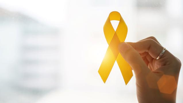 hand holding a yellow ribbon representing suicide prevention and mental health services at central state university hbcu wilberforce