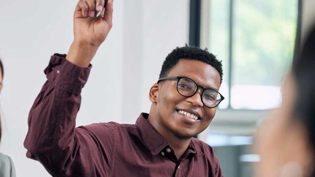 Student raises hand in a class