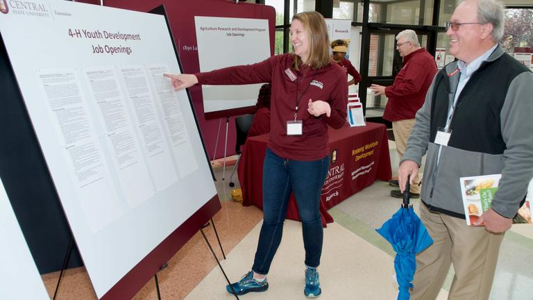 A researcher points to their poster abstract during Central State University's Land-Grant open house and research facility groundbreaking