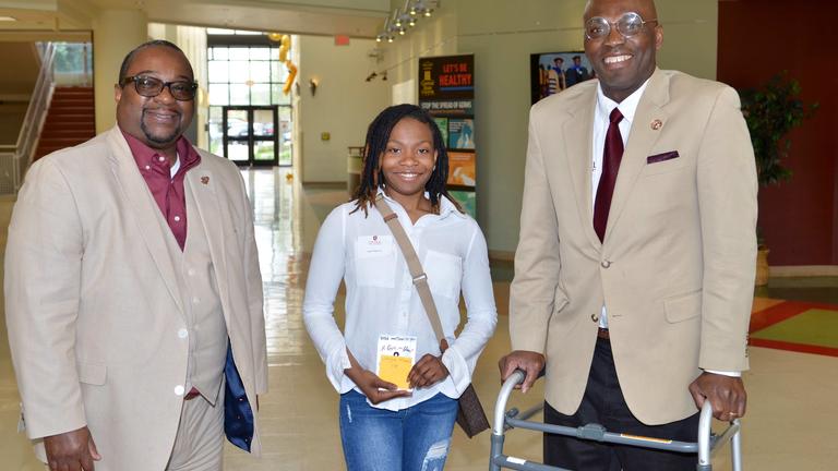 three people smile for the camera at Central State University