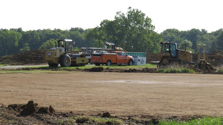 Trucks park at the site of the new Land-Grant research facility