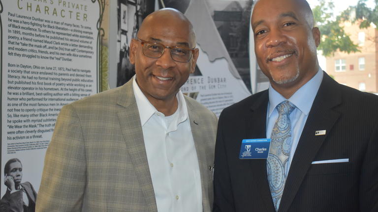 two men stand in front of a display at the Black Farming Conference in Wilberforce, Ohio