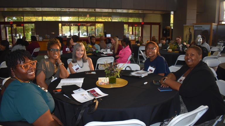 people sit around a table with a black tablecloth