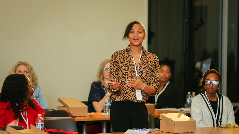 a participant in the RISE to the Challenge Summit asks a question of panelists during a workshop at Central State University