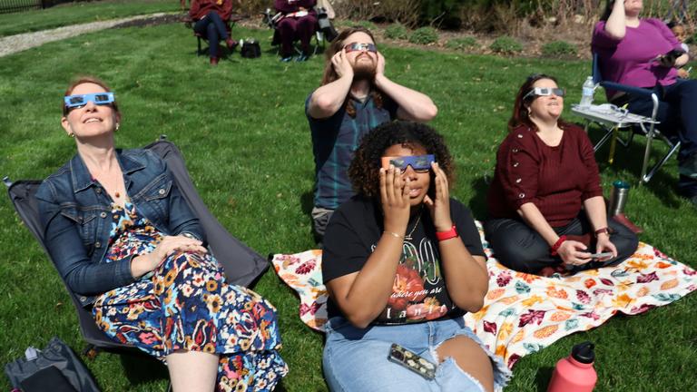 a group of five people watching the eclipse