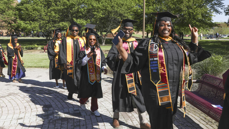 graduates in the processional across campus to the football stadium