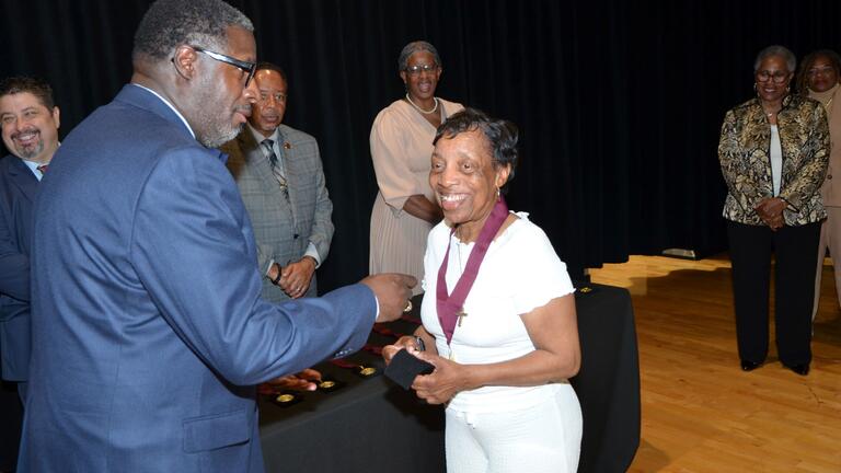 anthony gardner bestows golden class medallion on a member of the golden class