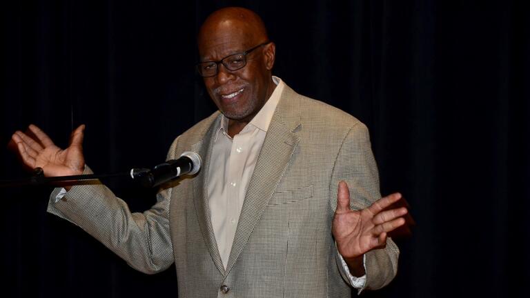 a man holding his hands out at a microphone
