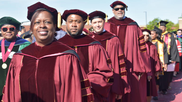 board of trustees members in caps and gowns
