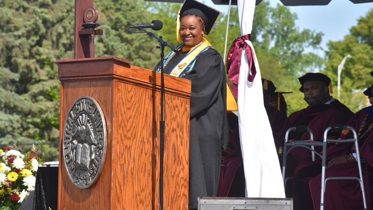 mer'kyah warren smiles broadly at podium