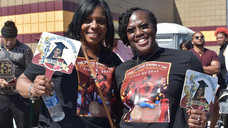 merical harris family members with shirts and signs celebrating graduation