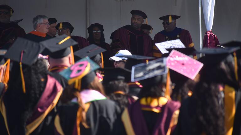 platform guests seen over the heads of graduates