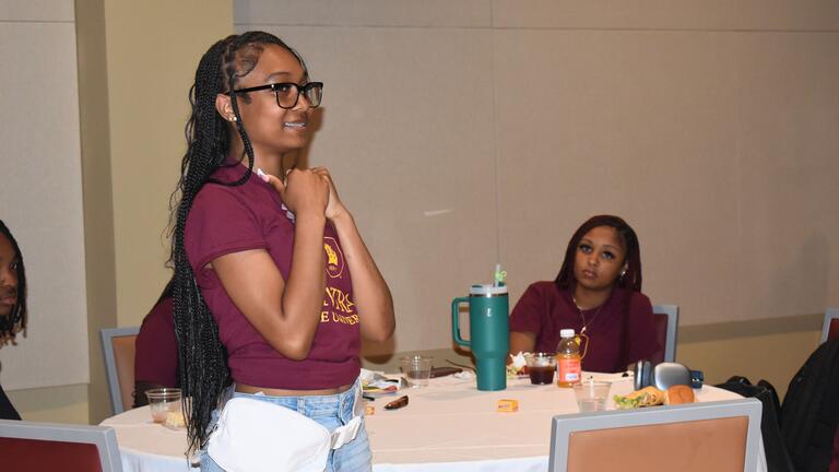 a young woman stands to introduce herself during the keybank scholars program