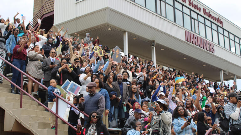 a crowd watches from the stadium seating