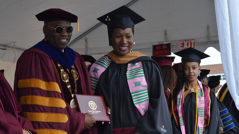 President Kuti poses with a student and diploma