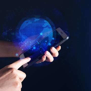 A pair of hands holding a mobile device with an abstract globe floating above screen