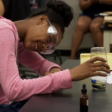 An African American youth wears protective glasses while doing a science experiment at a Central State University Extension summer camp